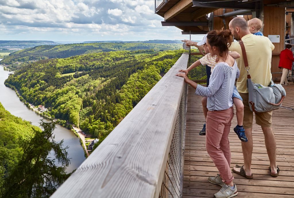 Eine Familie mit Kindern blickt auf das Gelände des Abenteuerwalds Saarschleife.