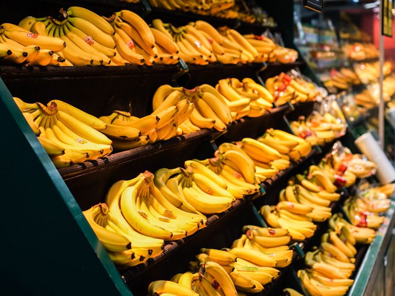 Das Bild zeigt mit Bananen gefüllte Regale im Supermarkt.