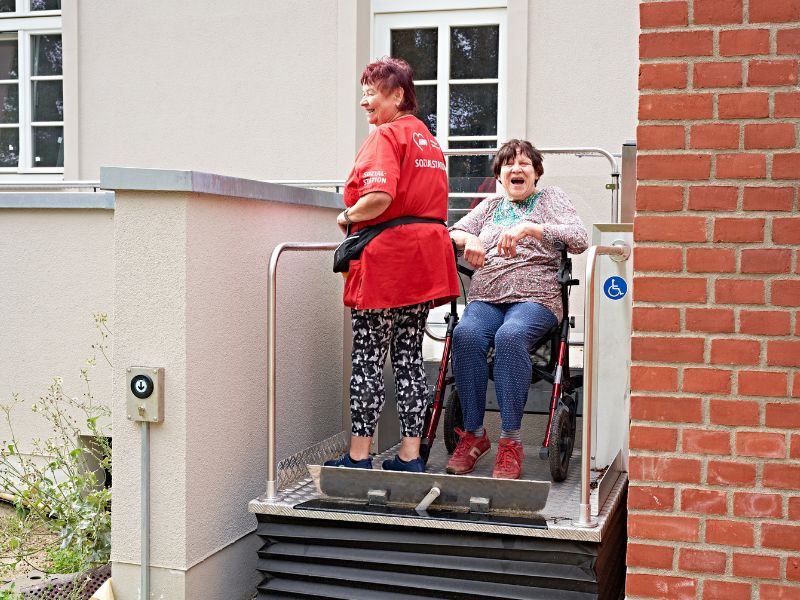 Zwei Frauen benutzen eine Rampe, um barrierefrei in ihre Wohnung zu gelangen.