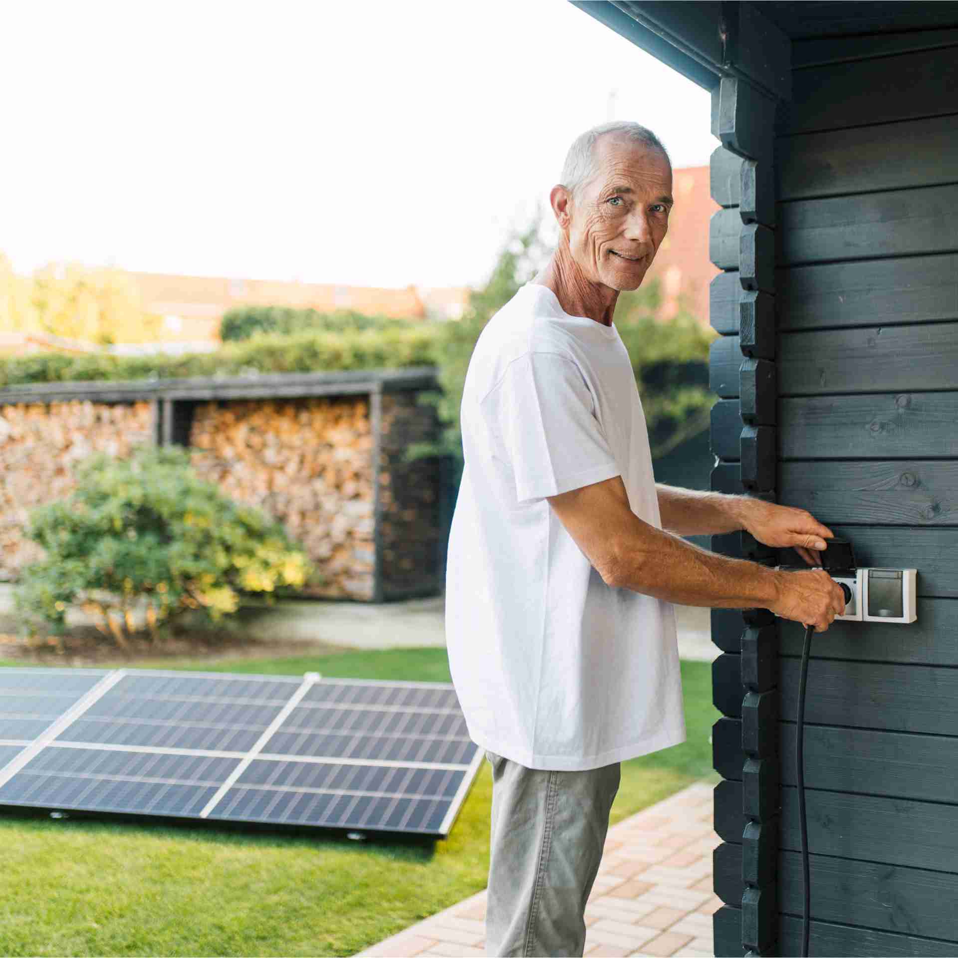 Mann installiert eine Solaranlage im Garten.