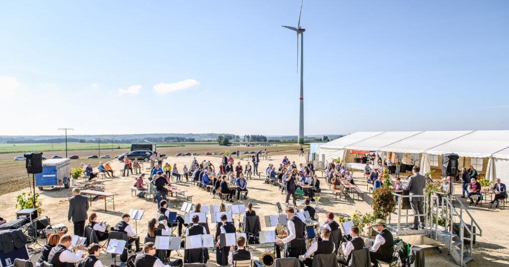 Menschen und Musikverein feiern die Einweihung des Schenkwindrads Gnannenweiler.