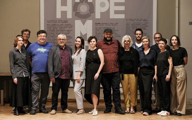 Eine Gruppe von Menschen steht vor dem Plakat der Hope-Ausstellung