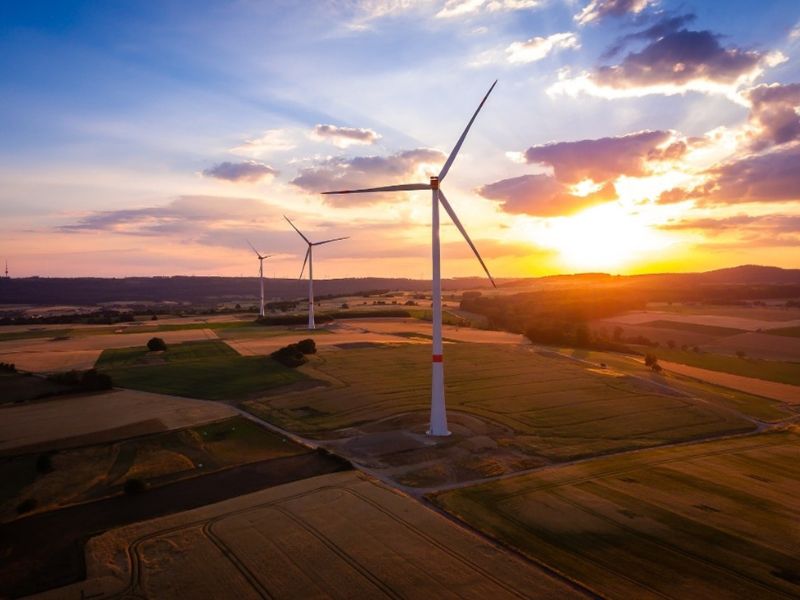 Windräder auf Land vor einem Abendhimmel 