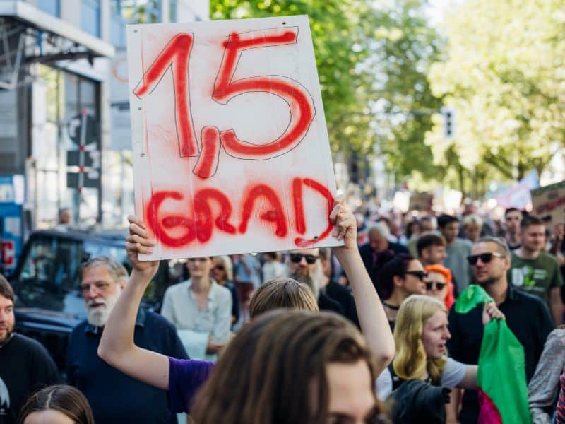 Bei einem Klimastreik wird ein Plakat mit der Aufschrift 1,5 Grad hochgehalten.