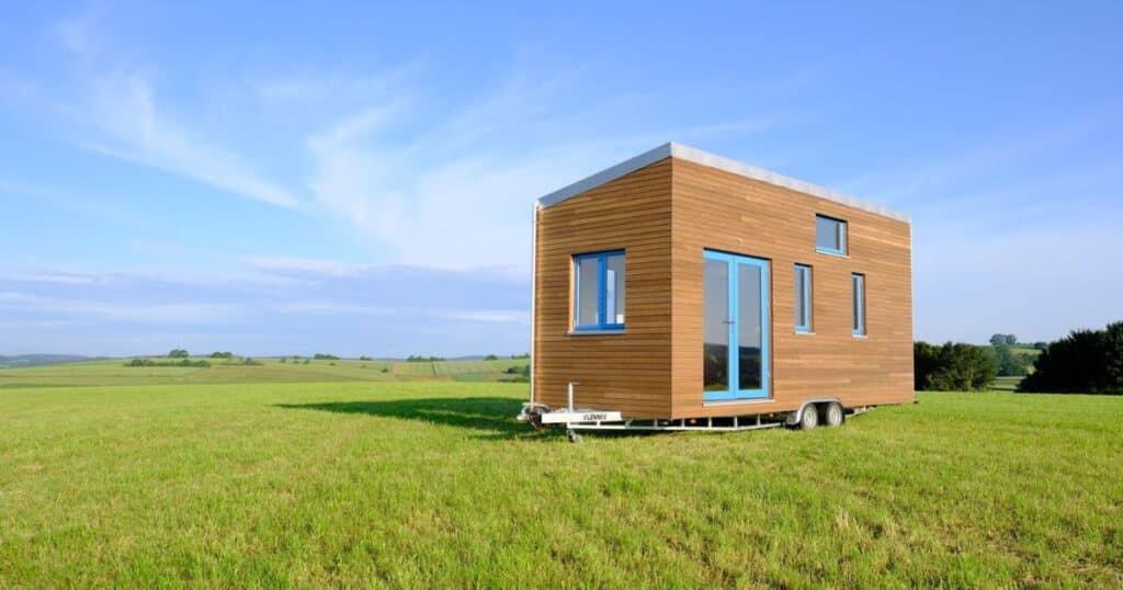 Ein Tiny House auf einer grünen Wiese.