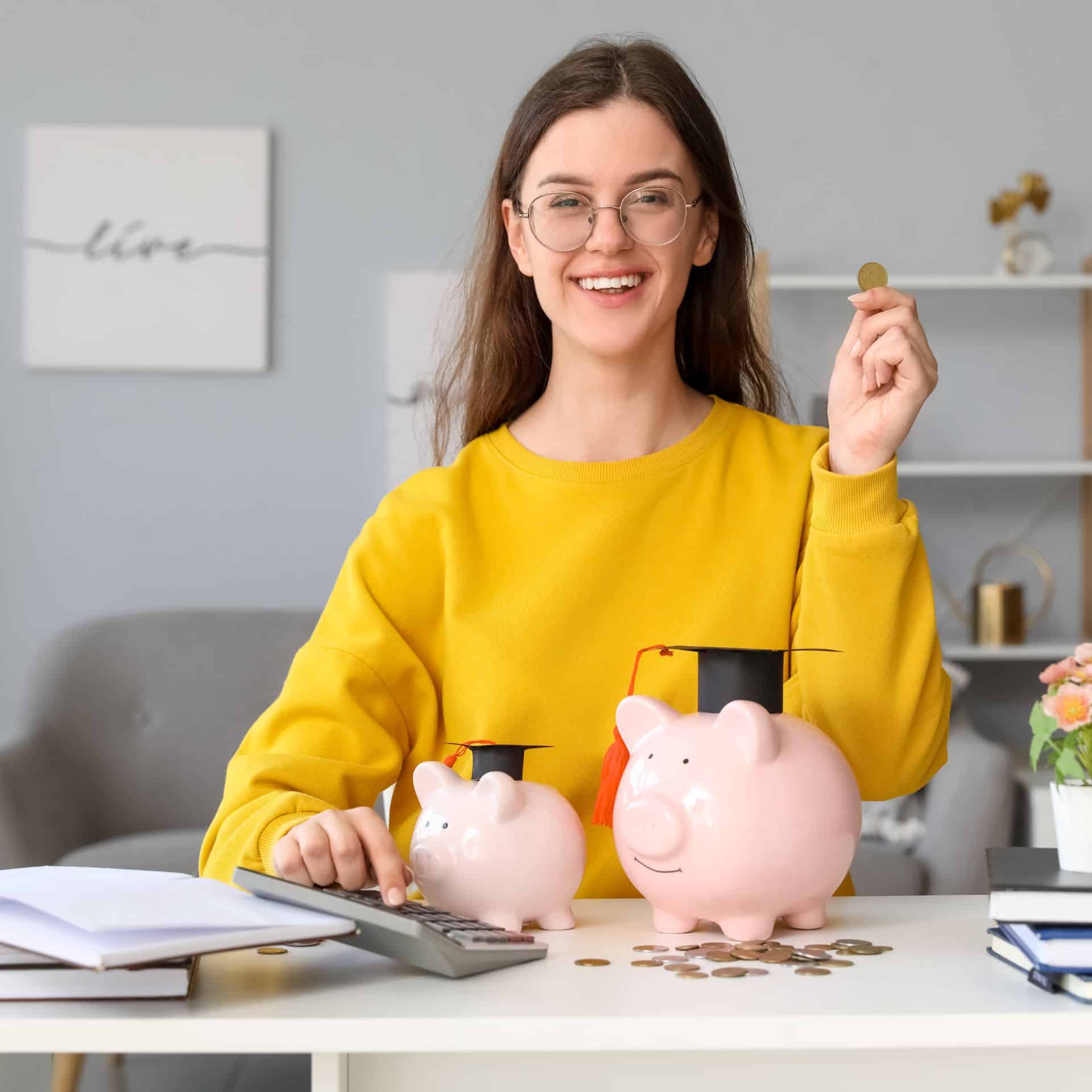 Eine junge Frau sitzt am Schreibtisch und kalkuliert ihre Finanzen.
