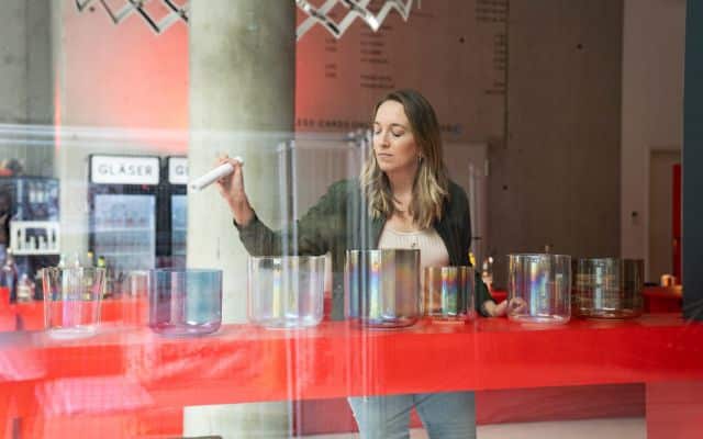 Annika List vor einer Reihe von Schalen, die sie erklingen lässt.