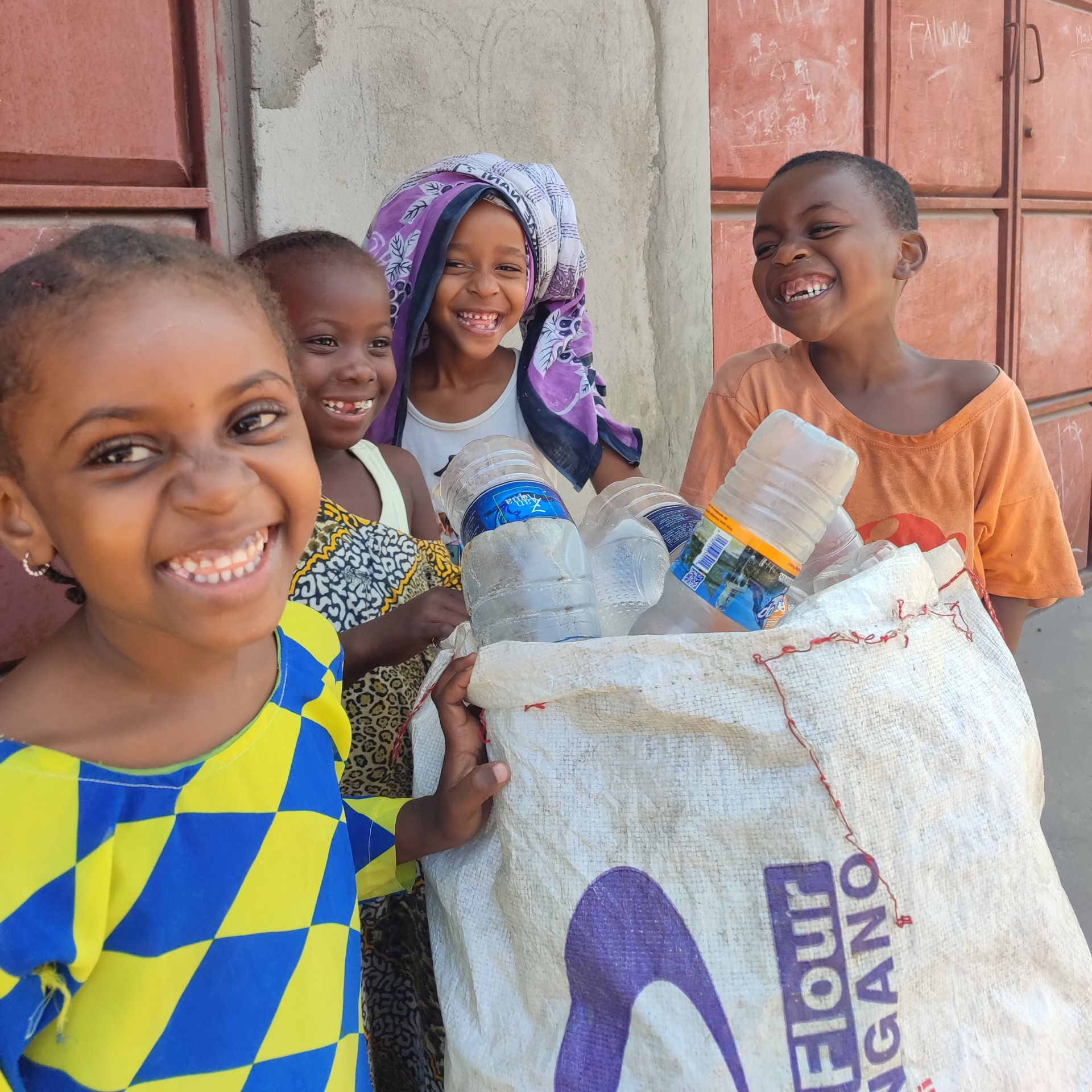 Vier Kinder in Somalia zeigen den Plastikmüll, den sie gesammelt haben.
