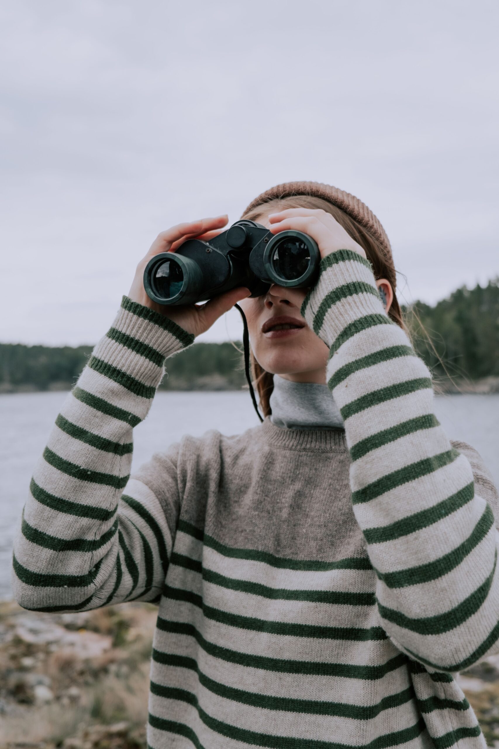 Das Bild zeigt eine Frau mit Fernglas.